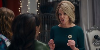 Movie still from “It's A Wonderful Binge” (2022), directed by Jordan VanDina – A woman talking to another woman in a green dress; Close Up shot, Over the shoulder angle