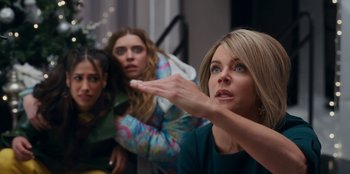 Movie still from “It's A Wonderful Binge” (2022), directed by Jordan VanDina – A group of women standing next to each other in a room; Medium shot, Low angle