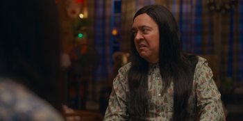 Movie still from “It's A Wonderful Binge” (2022), directed by Jordan VanDina – A person with long hair and a shirt on; Close Up shot, Over the shoulder angle