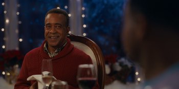 Movie still from “It's A Wonderful Binge” (2022), directed by Jordan VanDina – A man sitting at a table with a glass of red wine; Close Up shot, Over the shoulder angle