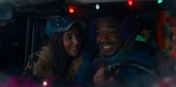 Movie still from “It's A Wonderful Binge” (2022), directed by Jordan VanDina – A man and a woman are smiling in the back of a car; Close Up shot, Over the shoulder angle