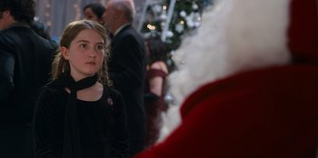Movie still from “It's A Wonderful Binge” (2022), directed by Jordan VanDina – A woman standing next to a man in a santa suit; Close Up shot, Over the shoulder angle