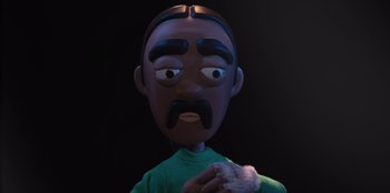 Movie still from “It's A Wonderful Binge” (2022), directed by Jordan VanDina – A black man with a mustache is holding something in his hand; Close Up shot, Over the shoulder angle