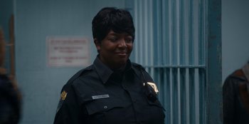 Movie still from “It's A Wonderful Binge” (2022), directed by Jordan VanDina – A woman in a uniform is smiling for the camera; Close Up shot, Over the shoulder angle
