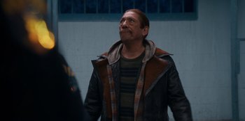 Movie still from “It's A Wonderful Binge” (2022), directed by Jordan VanDina – A man with a beard is standing in the street; Close Up shot, Over the shoulder angle