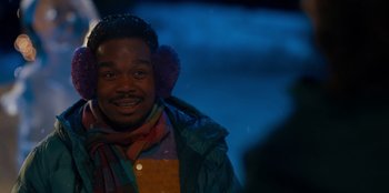 Movie still from “It's A Wonderful Binge” (2022), directed by Jordan VanDina – A person wearing a jacket and a scarf; Close Up shot, Over the shoulder angle