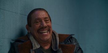 Movie still from “It's A Wonderful Binge” (2022), directed by Jordan VanDina – An older man smiling with his mouth open; Close Up shot, Low angle