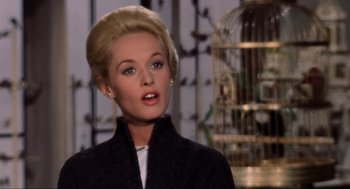 Movie still from “The Birds” (1963), directed by Alfred Hitchcock – A woman with blonde hair and blue eye shadow; Close Up shot, Low angle