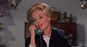 Movie still from “The Birds” (1963), directed by Alfred Hitchcock – A woman talking on a phone while sitting in a chair; Close Up shot, High angle