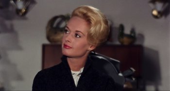 Movie still from “The Birds” (1963), directed by Alfred Hitchcock – A woman with blonde hair wearing a black jacket; Close Up shot, Low angle