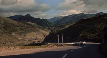 Movie still from “The Birds” (1963), directed by Alfred Hitchcock – A road with a mountain in the background; Extreme Wide shot, High angle