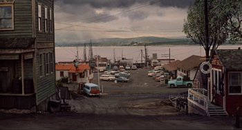 Movie still from “The Birds” (1963), directed by Alfred Hitchcock – An oil painting of a harbor with a lot of cars parked in it; Extreme Wide shot, High angle