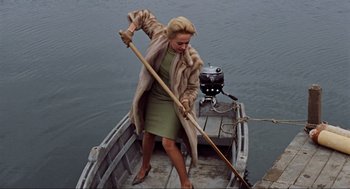 Movie still from “The Birds” (1963), directed by Alfred Hitchcock – A woman in a fur coat is on a boat; Medium shot, High angle