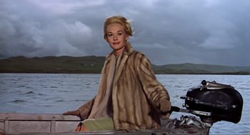 Movie still from “The Birds” (1963), directed by Alfred Hitchcock – A woman wearing a fur coat sitting on a boat; Medium shot, Low angle