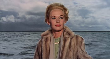 Movie still from “The Birds” (1963), directed by Alfred Hitchcock – A woman wearing a fur coat standing in front of a body of water; Close Up shot, Low angle