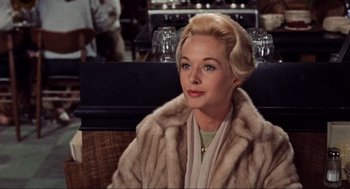Movie still from “The Birds” (1963), directed by Alfred Hitchcock – A woman with blonde hair wearing a fur coat; Close Up shot, Over the shoulder angle