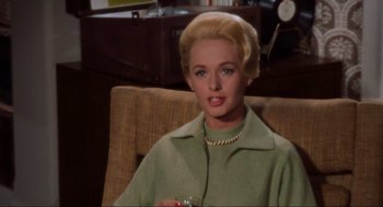 Movie still from “The Birds” (1963), directed by Alfred Hitchcock – A woman sitting in a chair holding a drink; Close Up shot, High angle