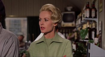 Movie still from “The Birds” (1963), directed by Alfred Hitchcock – A woman with blonde hair wearing a green jacket; Close Up shot, Low angle