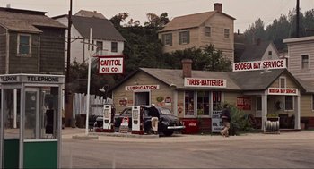 Movie still from “The Birds” (1963), directed by Alfred Hitchcock – An old fashioned gas station with cars parked in front of it; Extreme Wide shot, High angle
