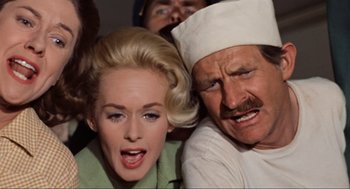 Movie still from “The Birds” (1963), directed by Alfred Hitchcock – A man and a woman are looking at the camera; Close Up shot, High angle