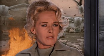 Movie still from “The Birds” (1963), directed by Alfred Hitchcock – A woman with blonde hair is looking at the camera; Close Up shot, Low angle