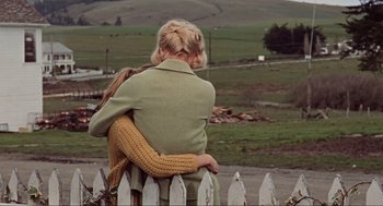 Movie still from “The Birds” (1963), directed by Alfred Hitchcock – A woman sitting on top of a wooden fence; Medium shot, Over the shoulder angle