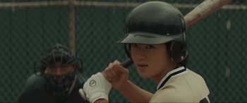 Movie still from “The Black Phone” (2021), directed by Scott Derrickson – A baseball player holding a bat while wearing a helmet; Close Up shot, Over the shoulder angle