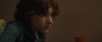 Movie still from “The Black Phone” (2021), directed by Scott Derrickson – A young boy is looking into the distance; Close Up shot, Low angle