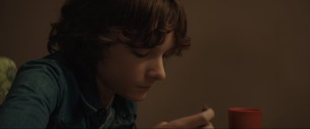 Movie still from “The Black Phone” (2021), directed by Scott Derrickson – A young boy is looking at his cell phone; Close Up shot, High angle