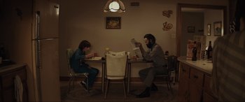 Movie still from “The Black Phone” (2021), directed by Scott Derrickson – A man and a woman sitting at a dinner table; Medium shot, Low angle