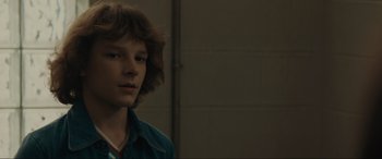 Movie still from “The Black Phone” (2021), directed by Scott Derrickson – A young man with brown curly hair wearing a blue shirt; Close Up shot, Over the shoulder angle