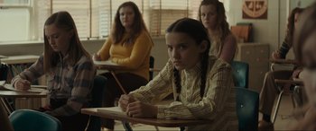 Movie still from “The Black Phone” (2021), directed by Scott Derrickson – A girl sitting at a desk in front of two other girls; Medium shot, Over the shoulder angle