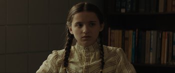 Movie still from “The Black Phone” (2021), directed by Scott Derrickson – A young girl with braids and a striped shirt; Close Up shot, Low angle