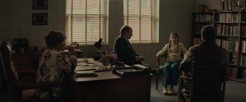 Movie still from “The Black Phone” (2021), directed by Scott Derrickson – A man and a woman sitting at a desk in front of a window; Wide shot, Over the shoulder angle