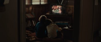 Movie still from “The Black Phone” (2021), directed by Scott Derrickson – Two children sitting on the floor watching television; Wide shot, High angle