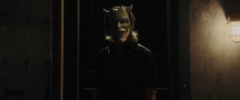 Movie still from “The Black Phone” (2021), directed by Scott Derrickson – A man wearing a demon mask in the dark; Medium shot, Low angle