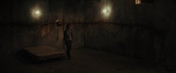 Movie still from “The Black Phone” (2021), directed by Scott Derrickson – A person standing in a room with a light hanging from the ceiling; Wide shot, High angle