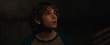 Movie still from “The Black Phone” (2021), directed by Scott Derrickson – A young boy looking up into the dark; Close Up shot, Low angle
