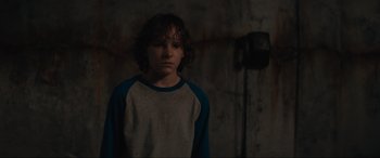 Movie still from “The Black Phone” (2021), directed by Scott Derrickson – A young boy standing in front of a wall; Close Up shot, Over the shoulder angle