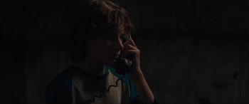 Movie still from “The Black Phone” (2021), directed by Scott Derrickson – A young man talking on a phone in the dark; Close Up shot, Low angle