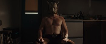 Movie still from “The Black Phone” (2021), directed by Scott Derrickson – A man with a horned mask sitting on a chair; Medium shot, Low angle