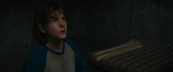 Movie still from “The Black Phone” (2021), directed by Scott Derrickson – A young man sitting in a dark room; Close Up shot, Over the shoulder angle