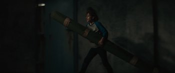 Movie still from “The Black Phone” (2021), directed by Scott Derrickson – A young boy carrying a large piece of wood; Medium shot, High angle