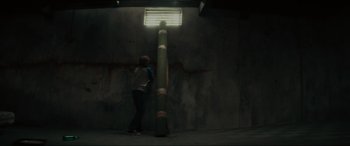 Movie still from “The Black Phone” (2021), directed by Scott Derrickson – A man standing next to a pole in a dark room; Wide shot, Low angle