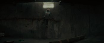 Movie still from “The Black Phone” (2021), directed by Scott Derrickson – A person hanging on to a wall in a dark room; Wide shot, Overhead angle