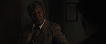 Movie still from “The Black Phone” (2021), directed by Scott Derrickson – An older black man in a suit and tie; Close Up shot, Over the shoulder angle