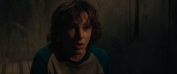 Movie still from “The Black Phone” (2021), directed by Scott Derrickson – A young boy is looking into the camera; Close Up shot, Over the shoulder angle