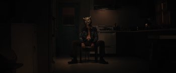 Movie still from “The Black Phone” (2021), directed by Scott Derrickson – A man sitting on a chair wearing a mask; Medium shot, Low angle
