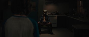 Movie still from “The Black Phone” (2021), directed by Scott Derrickson – A man sitting in a chair wearing an animal mask; Medium shot, Over the shoulder angle