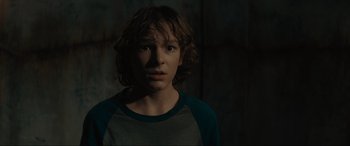 Movie still from “The Black Phone” (2021), directed by Scott Derrickson – A young boy with a sad look on his face; Close Up shot, Over the shoulder angle